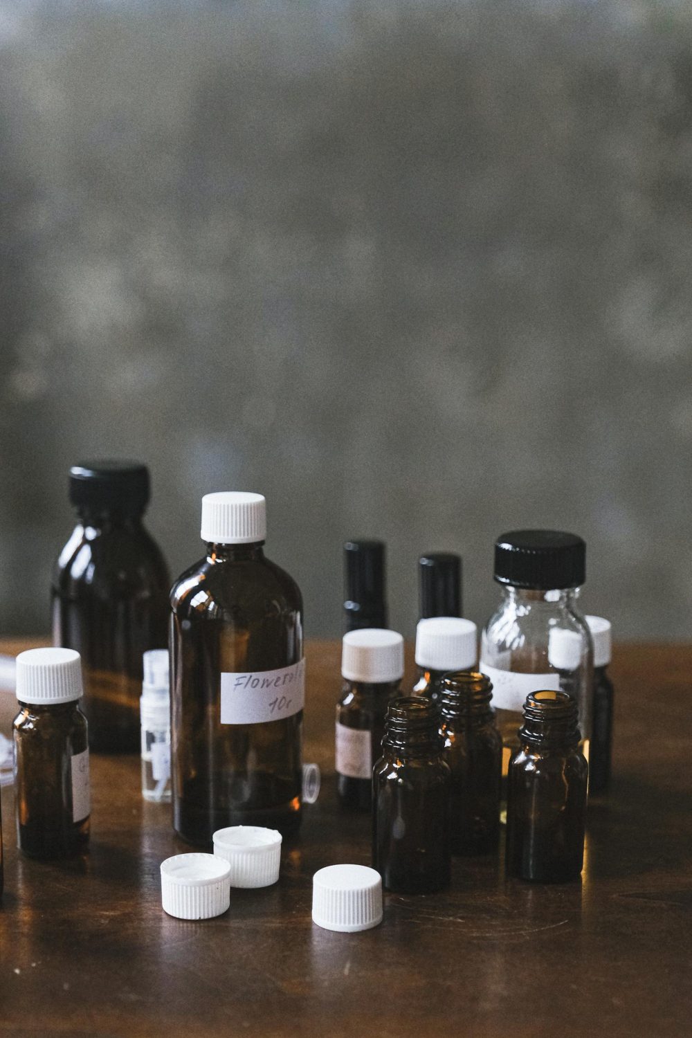 Collection of glass bottles containing essential oils arranged on a wooden table.